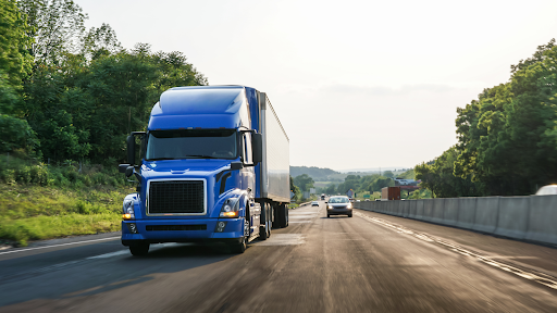 A truck travels down a highway in light traffic.