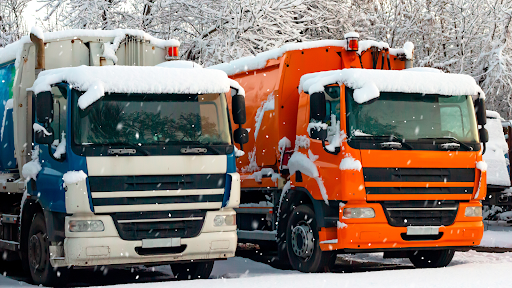 Two trucks parked together in the snow.