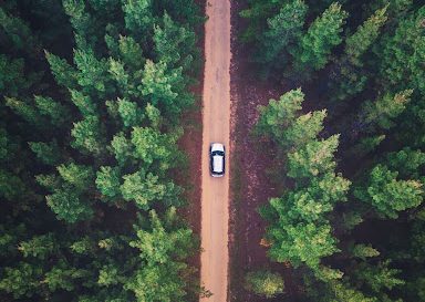 a white car driving on an empty rural road
