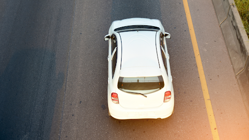 A car pictured from above, driving on a highway