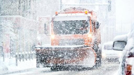 truck plowing a snowy road