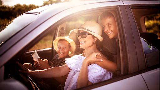 Smiling mother and children in an electric vehicle, enjoying a smooth and quiet ride with EV-optimized tires.